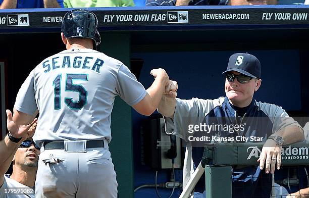 Manager Eric Wedge of the Seattle Mariners congratulates Kyle Seager after he scored against the Kansas City Royals in the third inning on Thursday,...