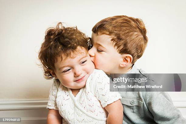 little boy kissing little girl. - baby boy and girl stockfoto's en -beelden