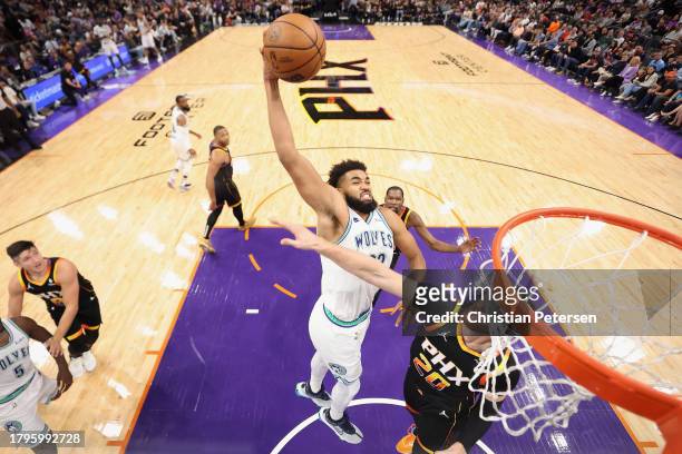 Karl-Anthony Towns of the Minnesota Timberwolves slam dunks the ball over Jusuf Nurkic of the Phoenix Suns during the second half of the NBA game at...