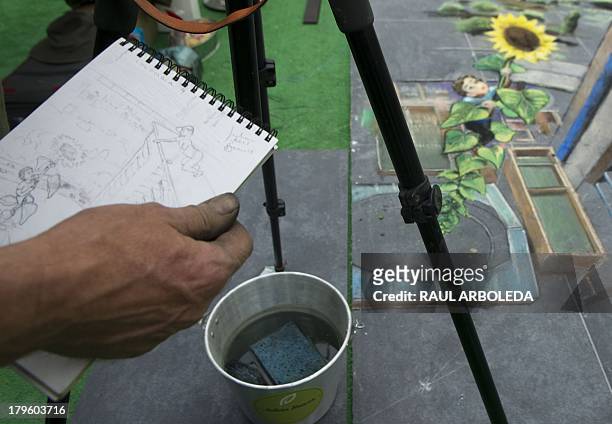 British artist Julian Beever , specialized in pavement drawings, wall murals and realistic paintings, carries a sketch of his painting in a shopping...