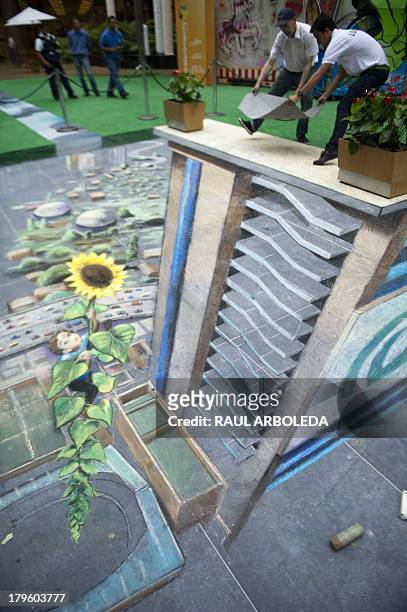 British artist Julian Beever , specialized in pavement drawings, wall murals and realistic paintings, works on his painting in a shopping center in...