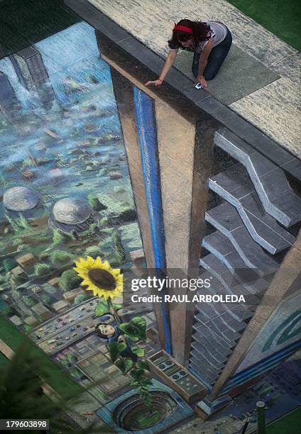 Woman poses by the work of British artist Julian Beever, specialized in pavement drawings, wall murals and realistic paintings, made in a shopping...