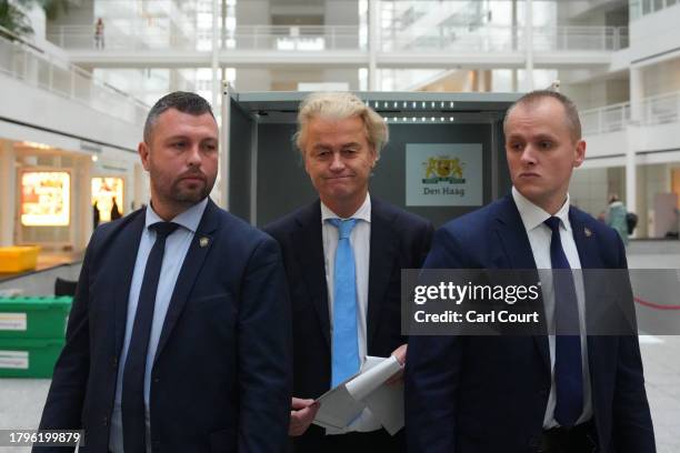 Bodyguards flank Geert Wilders , a Dutch right-wing politician and leader of the Party for Freedom , as he casts his vote in the Dutch general...