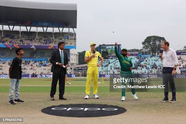 Pat Cummins of Australia and Temba Bavuma of South Africa take part in the coin toss alongside Match Referee, Javagal Srinath during the ICC Men's...