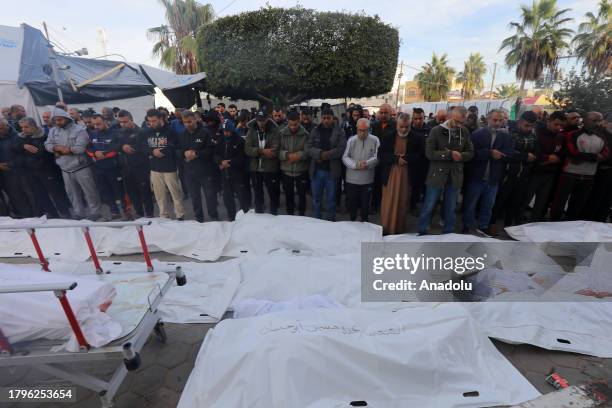 Relatives of Palestinians who lost their lives in Israeli attacks, perform funeral prayer after the bodies are taken from the morgue of Al-Aqsa...