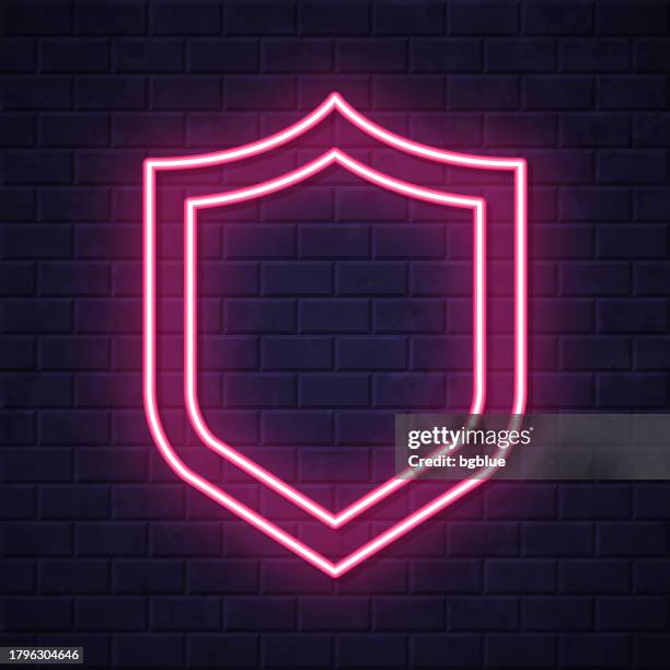 shield. glowing neon icon on brick wall background - security guard night stock illustrations