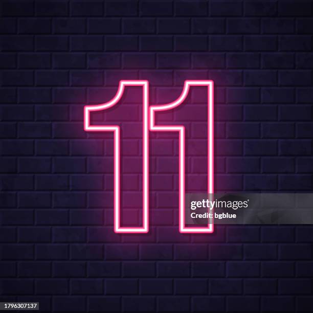 11 - number eleven. glowing neon icon on brick wall background - number 11 stock illustrations