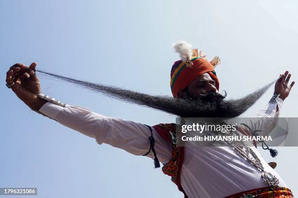 Man displays his moustache during a moustache competition at the annual fair at Pushkar, in India's Rajasthan state on November 22, 2023.