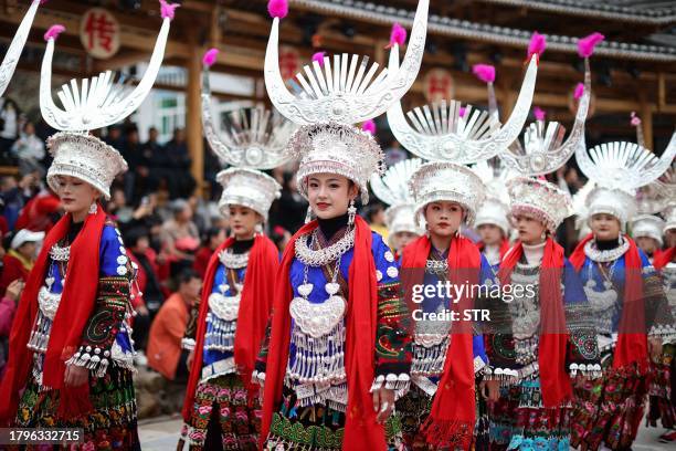 Women of the Miao ethnic minority, dressed in traditional costumes, take part in the celebration of the Guzang Festival in Leishan county, in China's...