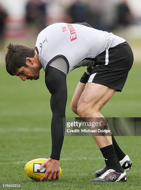 Quinten Lynch picks up the ball during a Collingwood Magpies AFL training session at Olympic Park on September 6, 2013 in Melbourne, Australia.