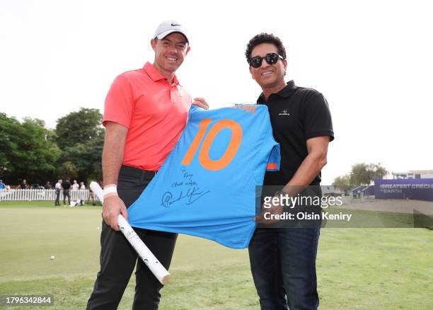 Rory McIlroy of Northern Ireland receives a gift of a signed India jersey and cricket stump from Sachin Tendulkar, former Indian cricket player...