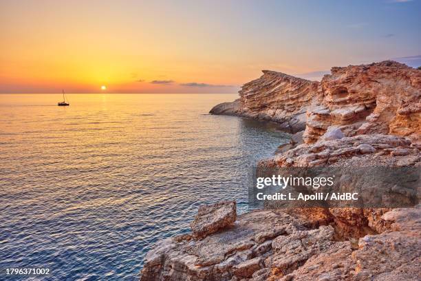 punta galera, baia panoramica con barca a vela al tramonto, ibiza, spagna - ibiza foto e immagini stock