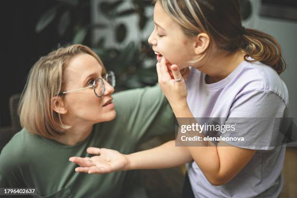 tochter zeigt mama einen verlorenen zahn - menschlicher mund stock-fotos und bilder