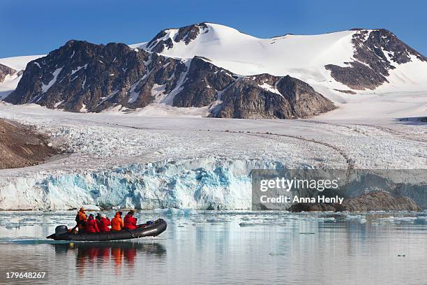 arctic tourists cruising glacier in svalbard - bote neumático fotografías e imágenes de stock