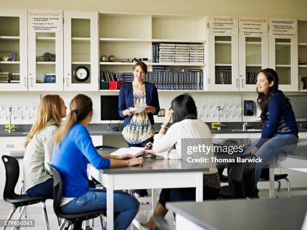 teacher in discussion with students in classroom - 2013newwomen stock pictures, royalty-free photos & images