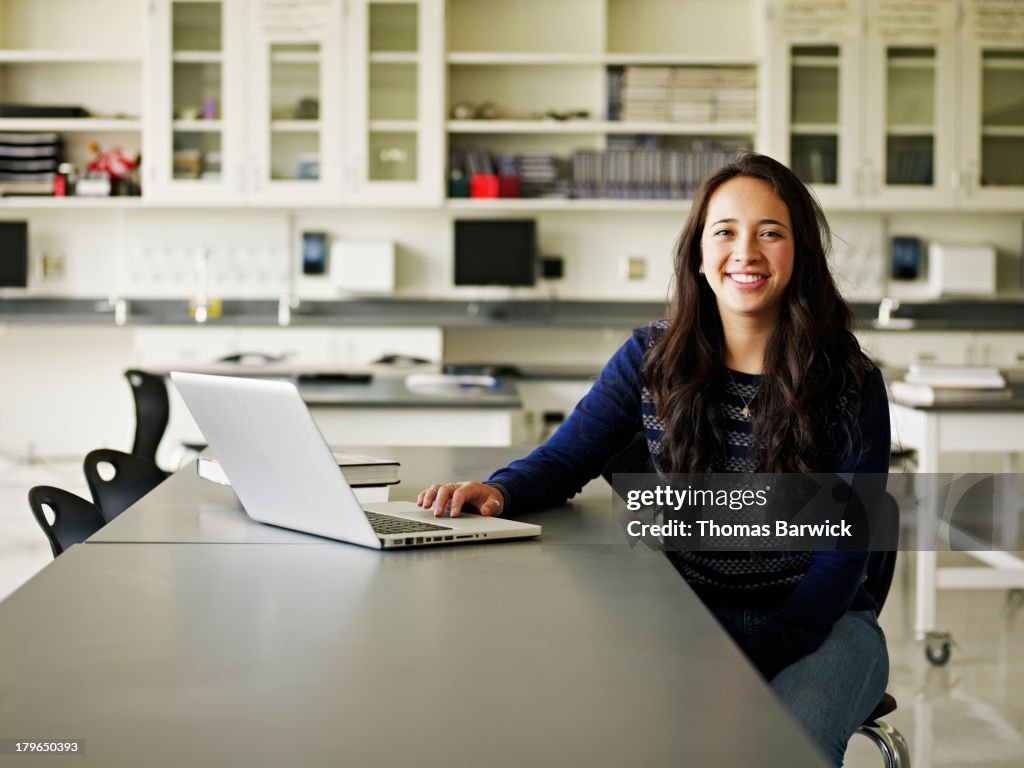 Portrait of student working on laptop in classroom