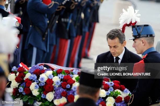 France's President Nicolas Sarkozy lays a wreath onto the tomb of the Unknown soldier at the Arc de Triomphe in Paris on November 11, 2011 as part of...