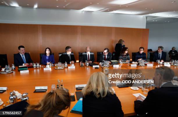 German Chancellor Olaf Scholz and members of his government wait for the start of the weekly cabinet meeting at the Chancellery in Berlin on November...