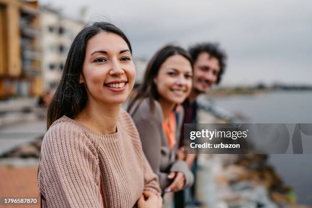 three young friends enjoying the view from the pier in malmo in sweden - malmo building stock pictures, royalty-free photos & images