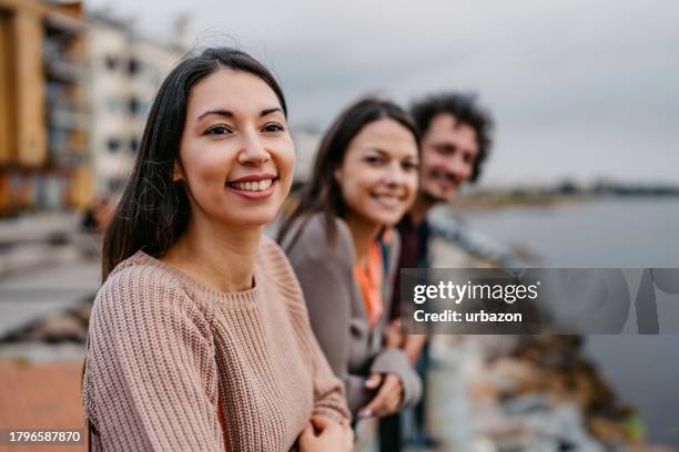 three young friends enjoying the view from the pier in malmo in sweden - malmo stock pictures, royalty-free photos & images