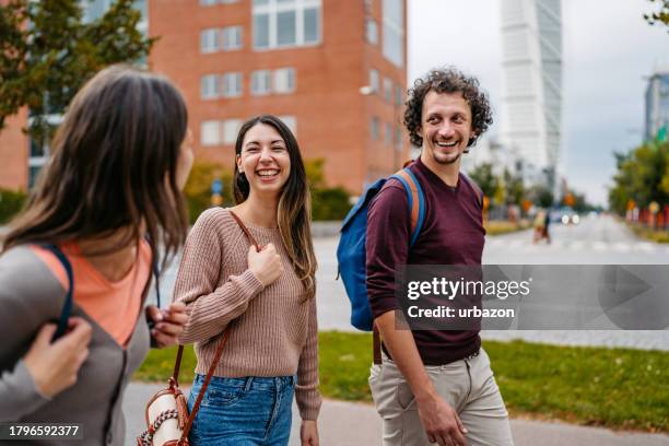 three young friends walking on the street in malmo in sweden - malmo stock pictures, royalty-free photos & images