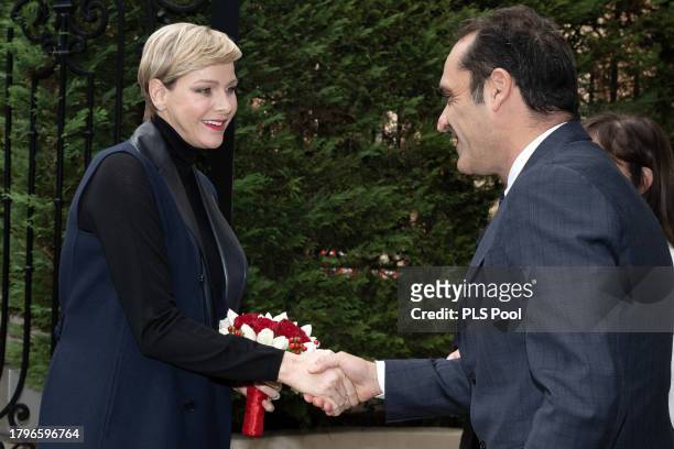 Princess Charlene of Monaco shakes hands with Frederic Platini during the Red Cross Gifts Distribution on November 16, 2023 in Monaco, Monaco.