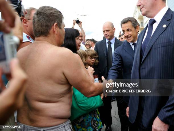 French President Nicolas Sarkozy meets vacationers along the beach in Cap d'Agde, southern France, on July 26, 2011 during a visit on tourism matters...