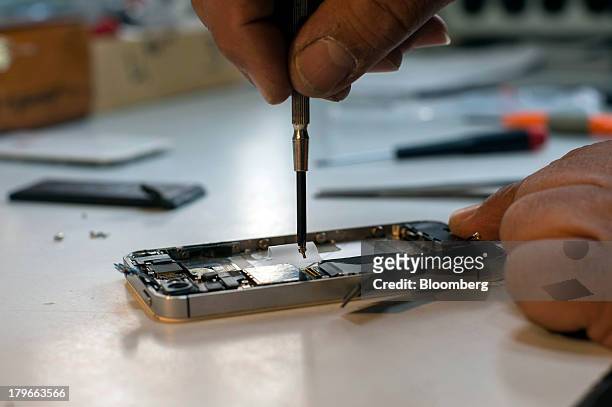 Michael Ghadieh, owner of Fix My Phone SF, fixes an Apple Inc. IPhone at his shop in San Francisco, California, U.S., on Friday, Aug. 23, 2013. On...