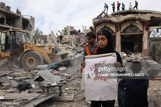 Palestinian boy displays a drawing unearthed from the rubble of a building at the site of Israeli bombardment on Rafah, in the southern Gaza Strip on...
