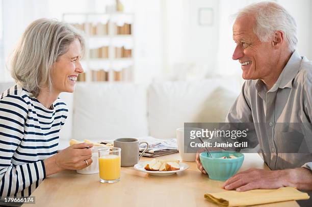 senior couple eating breakfast together - healthy older couple stockfoto's en -beelden