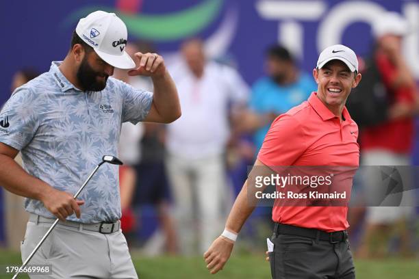 Rory McIlroy of Northern Ireland smiles alongside Jon Rahm of Spain whilst leaving the 18th green during Day One of the DP World Tour Championship on...