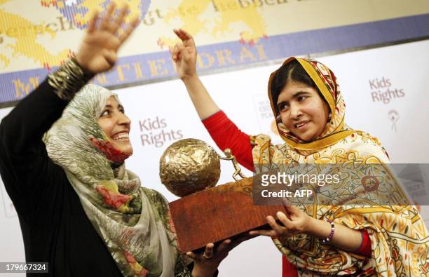Year old Malala Yousafzai from Pakistan receives a trophy from Yemeni Civil Rights activist and 2011 Nobel Peace Prize winner Tawakkul Karman after...