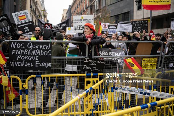 Demonstrator holds on to a fence during a protest against the investiture of Pedro Sanchez on the day the second session of the plenary session in...