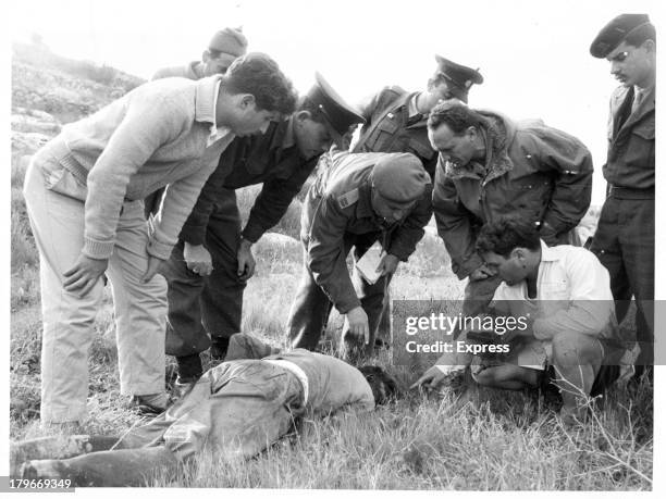 Police in the Gaza strip inspect the body of a Kibbuz shepherd killed the day after Israeli troops withdrew from the strip. The shepherd had gone out...