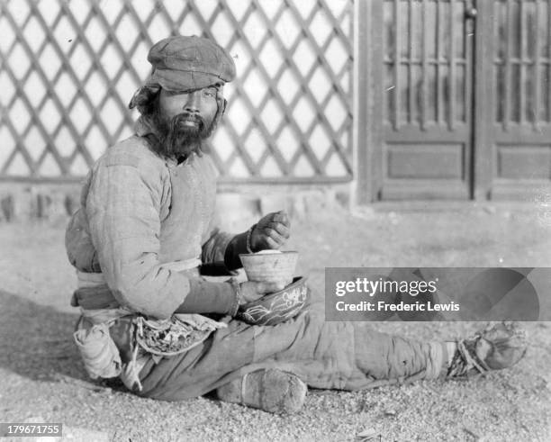 View of a Chinese peasant man eating a bowl of rice.