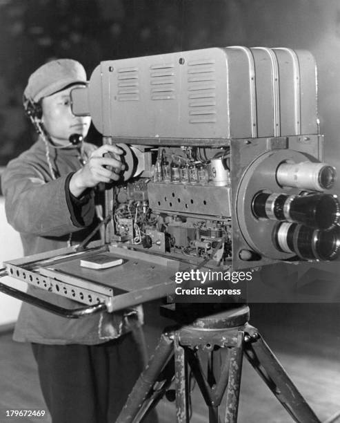 Red Chinese television cameraman films a sporting scene as part of the life of Tientsin. Beside him is his little red book that contains the Thought...