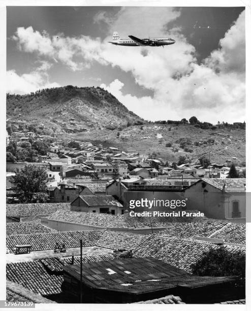 Pan Am airplane gets ready to land in Tegucigalpa, Honduras, surrounded by a mountain range.