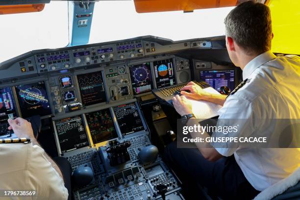 Pilots sit in the cockpit of an Emirates Airbus A 380-800 aircraft, powering one of its engines with a hundred per cent Sustainable Aviation Fuel ,...