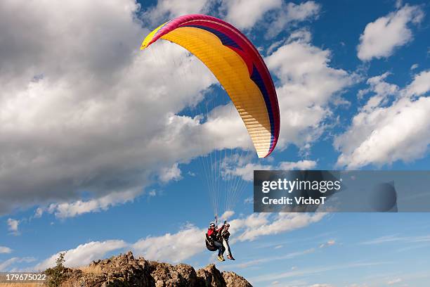 tandem paraglider starting a flight - tandem stock pictures, royalty-free photos & images