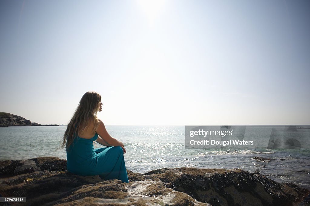 Girl Looking Over Rocks Woman Sitting On Rocks And Looking Out To Sea High-Res Stock Photo ...
