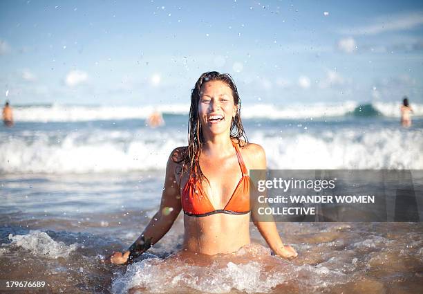 australian girl coming out of the water at beach - ocean shore stock-fotos und bilder