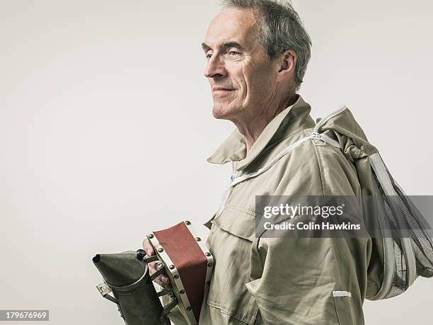 elderly man in beekeeper protective clothing - beekeeping stock pictures, royalty-free photos & images