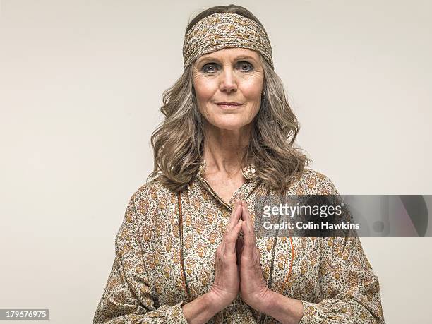 senior female praying - floral pattern shirt stock-fotos und bilder
