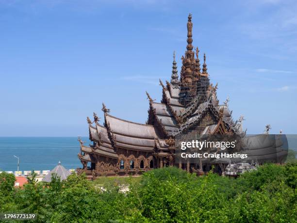 thai temple with ornate carvings shot on bright sunny blue sky day. pattaya thailand - plano fijo fotografías e imágenes de stock