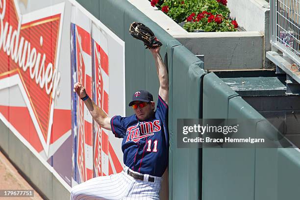 Clete Thomas of the Minnesota Twins makes a catch at the wall against the Cleveland Indians on July 21, 2013 at Target Field in Minneapolis,...