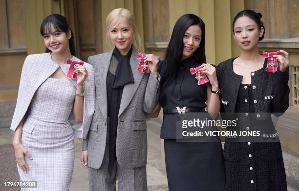 Pop band Blackpink's members, Lalisa Manoban, Roseanne Park, Jisoo Kim and Jennie Kim pose with their medals following a special investiture ceremony...