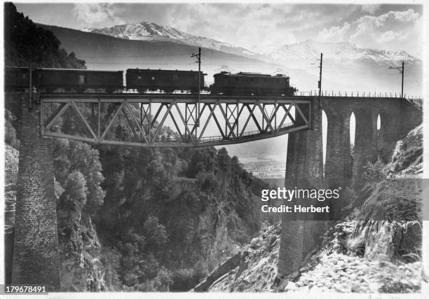 An impressive view of the Rhone Valley may be enjoyed from a Lotschberg railroad train traveling over the Baltschieder Bridge in Switzerland.