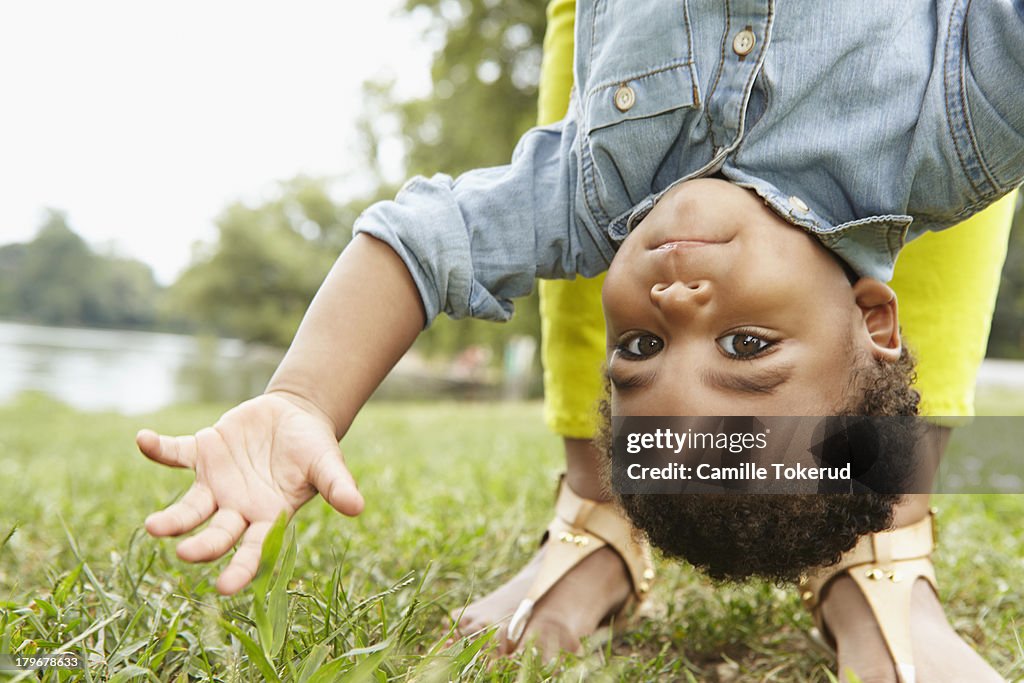 Close up of boy being held upside down by mother