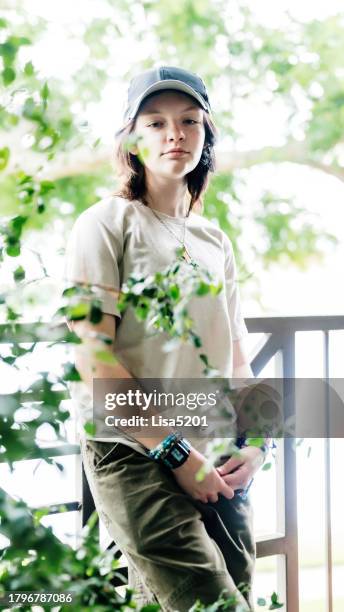 non-binary transgender teenager in casual portrait outdoors on apartment balcony - androgynous stock pictures, royalty-free photos & images