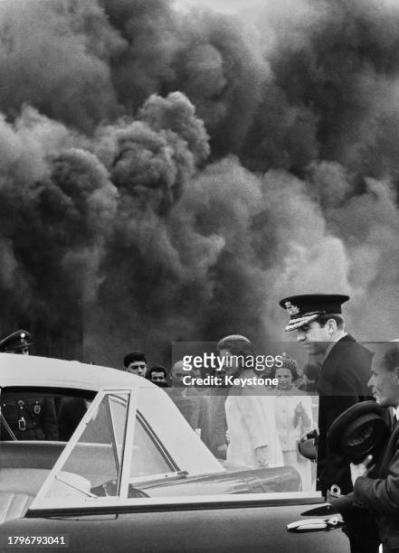 Greek Royals Queen Anne-Marie of Greece with her husband, Constantine II of Greece leave their car to watch the efforts of the fire service as they...